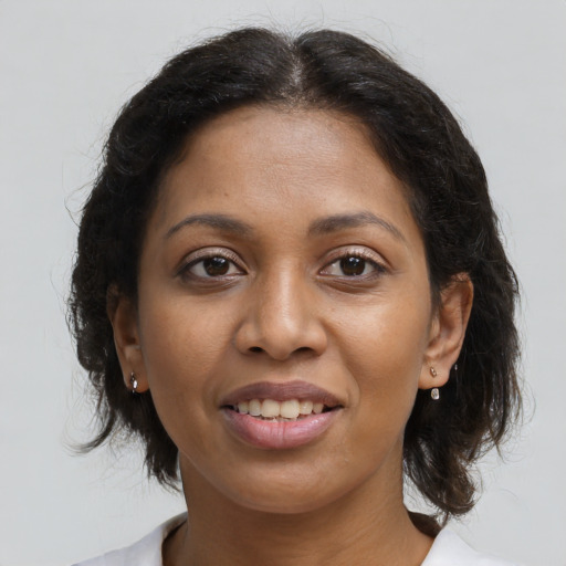 Joyful black young-adult female with medium  brown hair and brown eyes