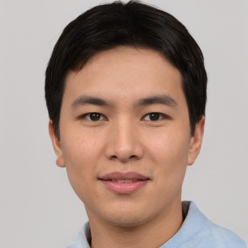 Joyful asian young-adult male with short  black hair and brown eyes