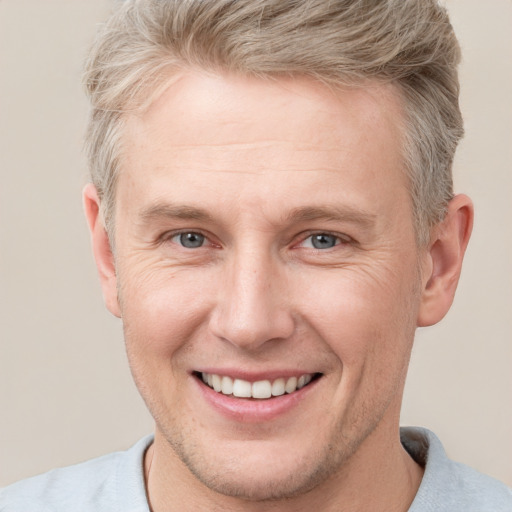 Joyful white adult male with short  brown hair and grey eyes