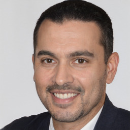 Joyful white adult male with short  black hair and brown eyes