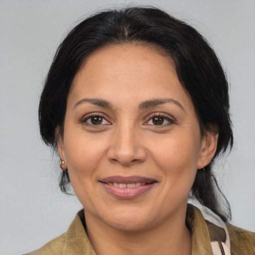 Joyful latino adult female with medium  brown hair and brown eyes