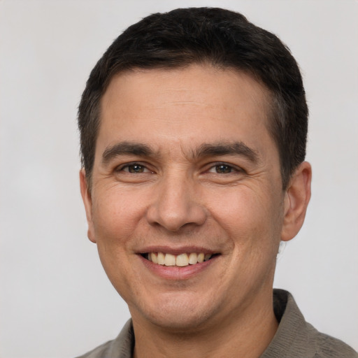 Joyful white adult male with short  brown hair and brown eyes