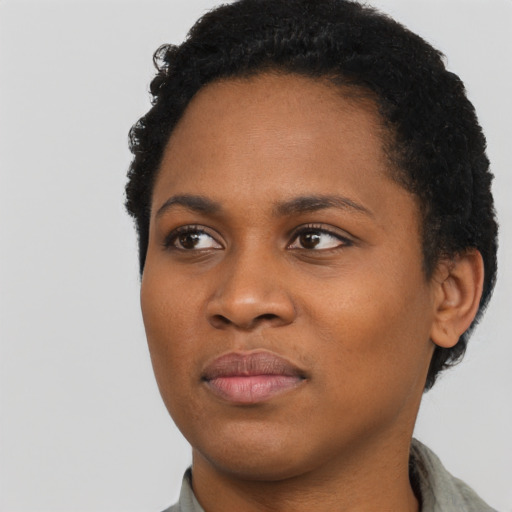Joyful black young-adult female with short  black hair and brown eyes