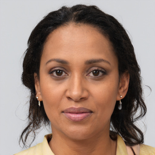 Joyful black adult female with long  brown hair and brown eyes