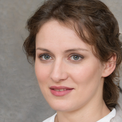 Joyful white young-adult female with medium  brown hair and blue eyes