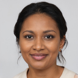 Joyful black adult female with medium  brown hair and brown eyes