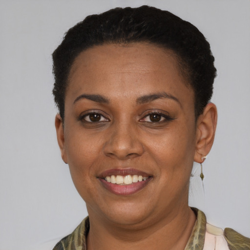 Joyful black young-adult female with short  black hair and brown eyes