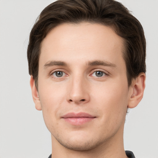 Joyful white young-adult male with short  brown hair and grey eyes