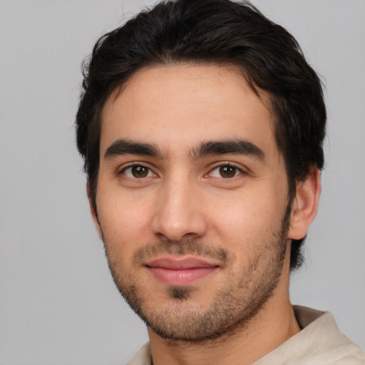 Joyful white young-adult male with short  black hair and brown eyes