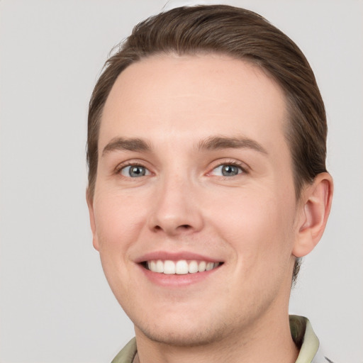 Joyful white young-adult male with short  brown hair and grey eyes