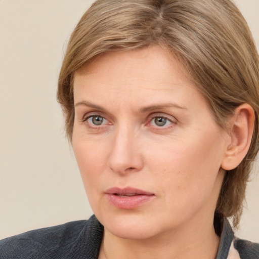 Joyful white adult female with medium  brown hair and blue eyes