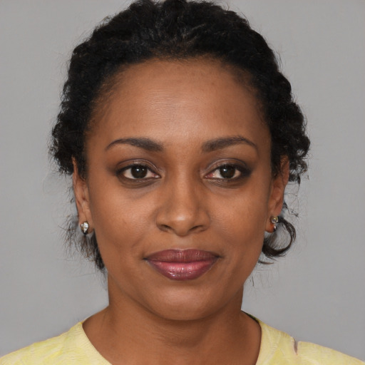 Joyful black young-adult female with short  brown hair and brown eyes