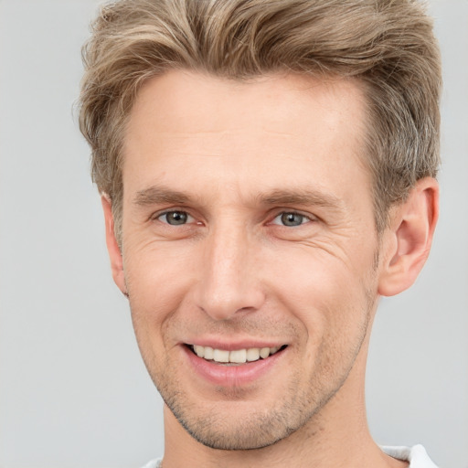 Joyful white adult male with short  brown hair and grey eyes