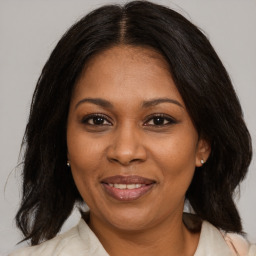 Joyful black adult female with medium  brown hair and brown eyes