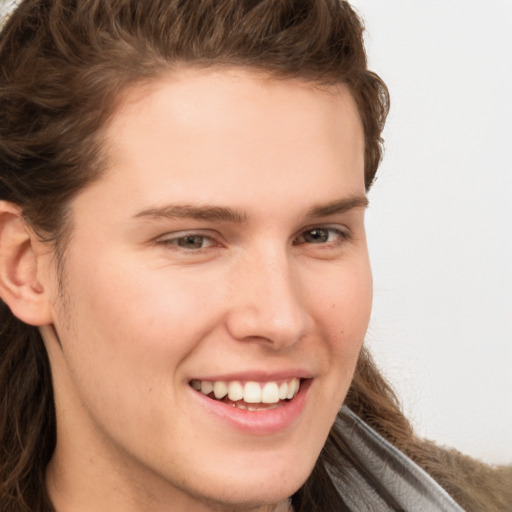 Joyful white young-adult male with long  brown hair and brown eyes