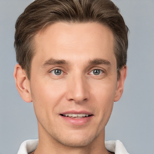 Joyful white young-adult male with short  brown hair and grey eyes