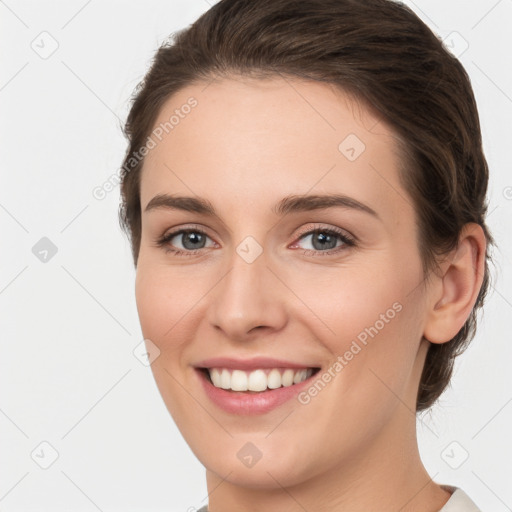 Joyful white young-adult female with medium  brown hair and grey eyes