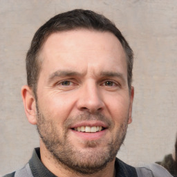 Joyful white adult male with short  brown hair and brown eyes