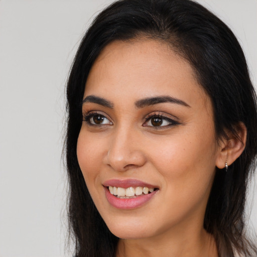 Joyful latino young-adult female with long  brown hair and brown eyes