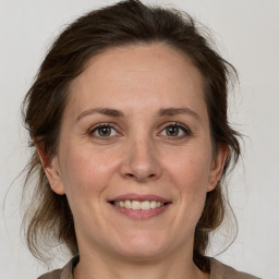 Joyful white adult female with medium  brown hair and grey eyes