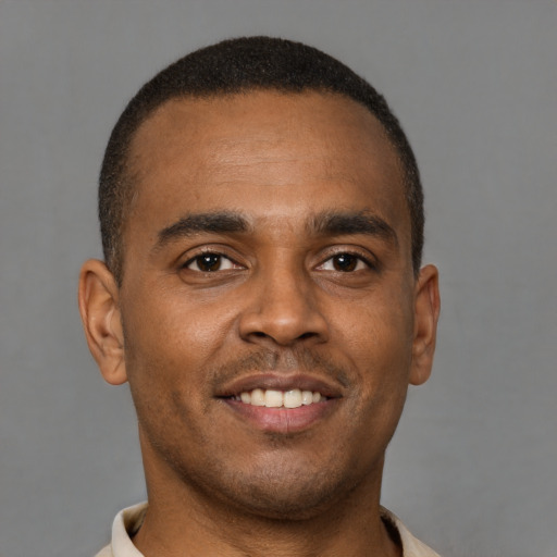 Joyful latino young-adult male with short  brown hair and brown eyes