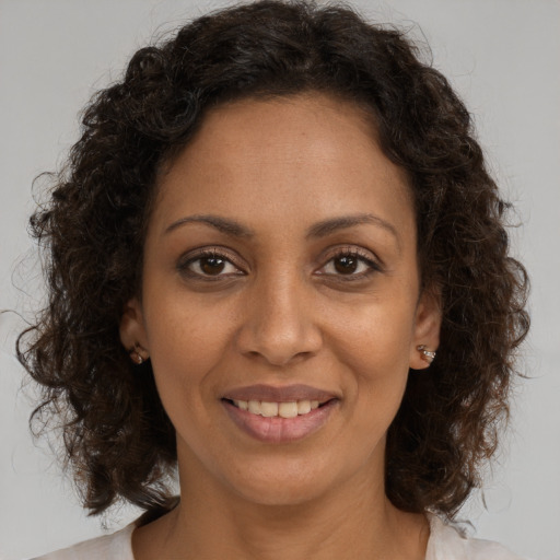 Joyful black young-adult female with medium  brown hair and brown eyes