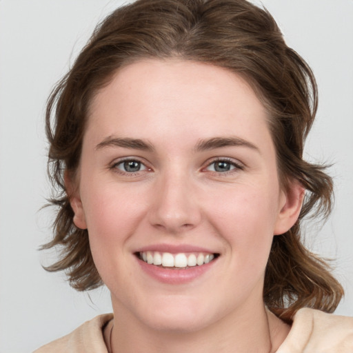 Joyful white young-adult female with medium  brown hair and blue eyes