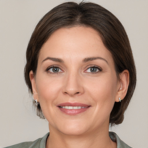 Joyful white adult female with medium  brown hair and brown eyes