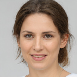 Joyful white young-adult female with medium  brown hair and green eyes