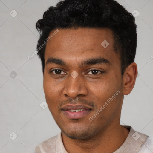 Joyful black young-adult male with short  black hair and brown eyes