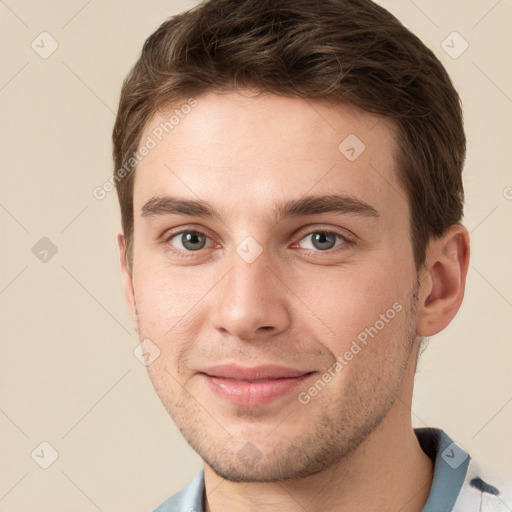 Joyful white young-adult male with short  brown hair and grey eyes