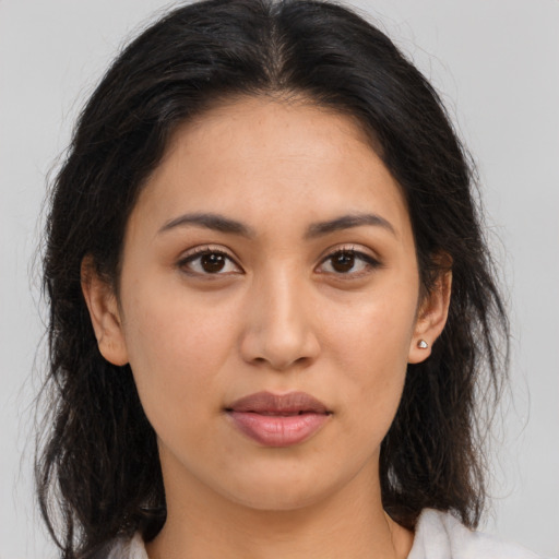 Joyful latino young-adult female with long  brown hair and brown eyes