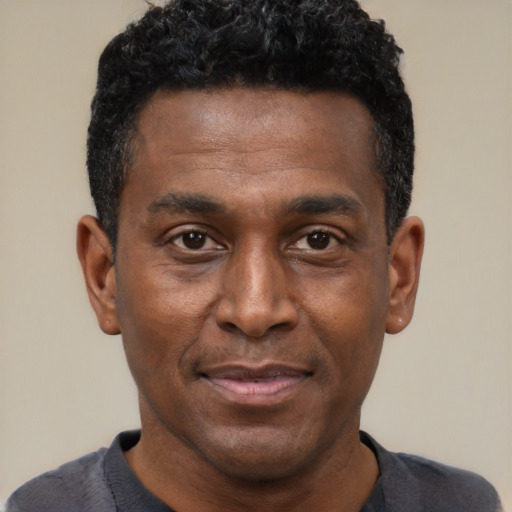 Joyful black young-adult male with short  black hair and brown eyes