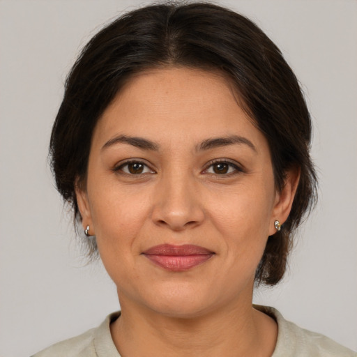 Joyful latino adult female with medium  brown hair and brown eyes