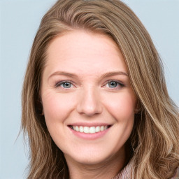 Joyful white young-adult female with long  brown hair and blue eyes