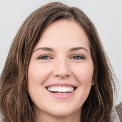 Joyful white young-adult female with long  brown hair and green eyes