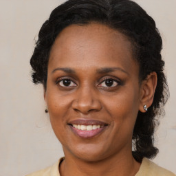 Joyful black adult female with medium  brown hair and brown eyes