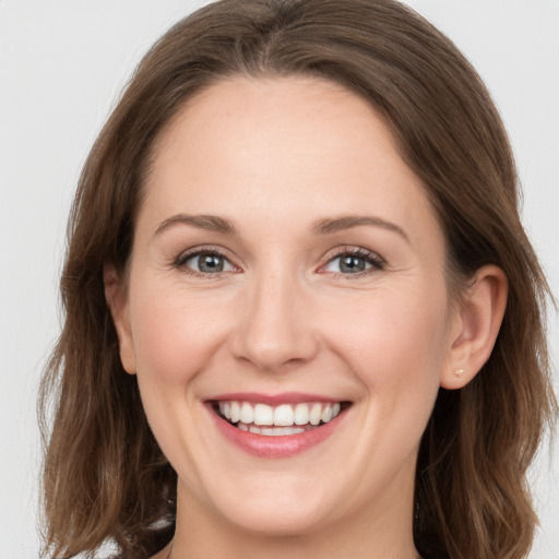 Joyful white young-adult female with long  brown hair and grey eyes