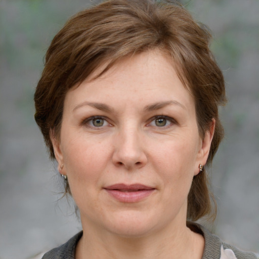 Joyful white adult female with medium  brown hair and grey eyes