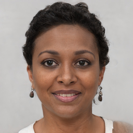 Joyful black young-adult female with short  brown hair and brown eyes