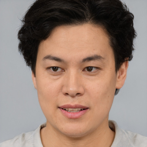 Joyful asian young-adult male with short  brown hair and brown eyes