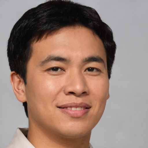 Joyful asian young-adult male with short  brown hair and brown eyes
