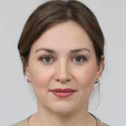 Joyful white young-adult female with medium  brown hair and grey eyes