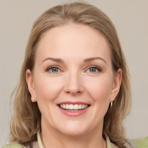 Joyful white young-adult female with medium  brown hair and green eyes