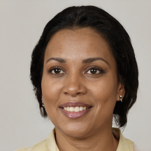 Joyful black adult female with medium  brown hair and brown eyes
