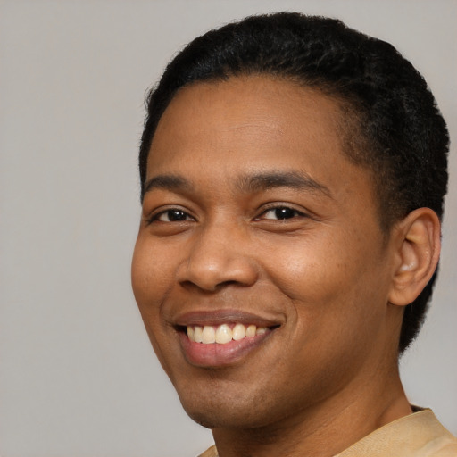 Joyful black young-adult male with short  black hair and brown eyes