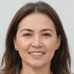 Joyful white young-adult female with long  brown hair and brown eyes