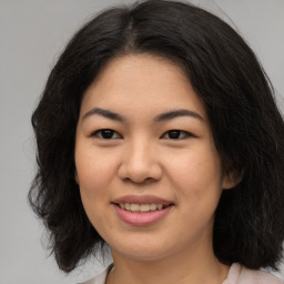 Joyful asian young-adult female with long  brown hair and brown eyes