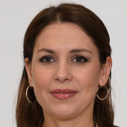 Joyful white adult female with long  brown hair and grey eyes