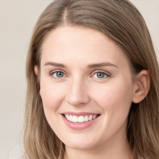 Joyful white young-adult female with long  brown hair and blue eyes